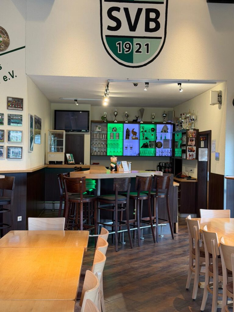 Innenansicht einer Sportbar mit SVB-Logo an der Wand.