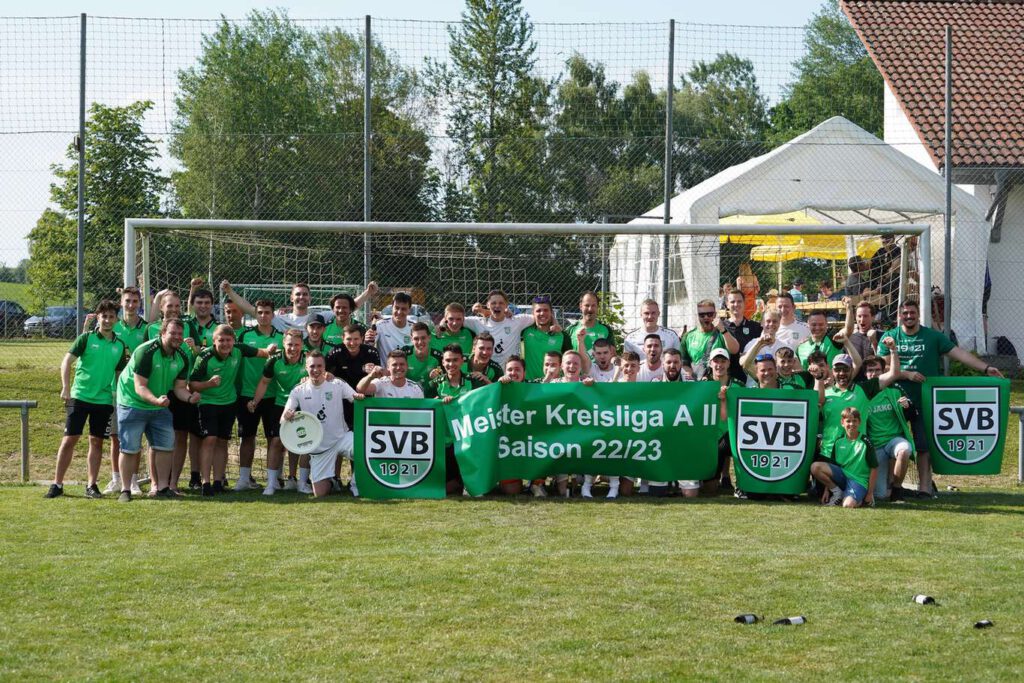 Eine Fußballmannschaft posiert fuer ein Gruppenfoto auf dem Spielfeld.