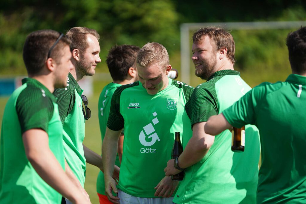 Eine Gruppe von Fußballspielern in gruenen Trikots trainiert im Freien.