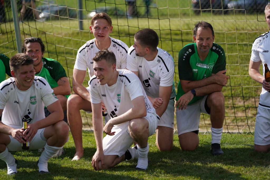 Eine Gruppe von Fußballspielern entspannt sich auf dem Spielfeld nach dem Training.