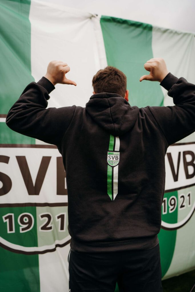 Person zeigt Fanliebe zu SVB vor Vereinsbanner